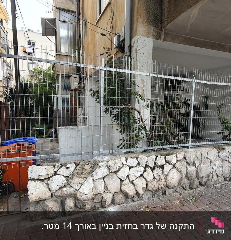 גדר מתכת עם מסגרת אבן על מדרכה